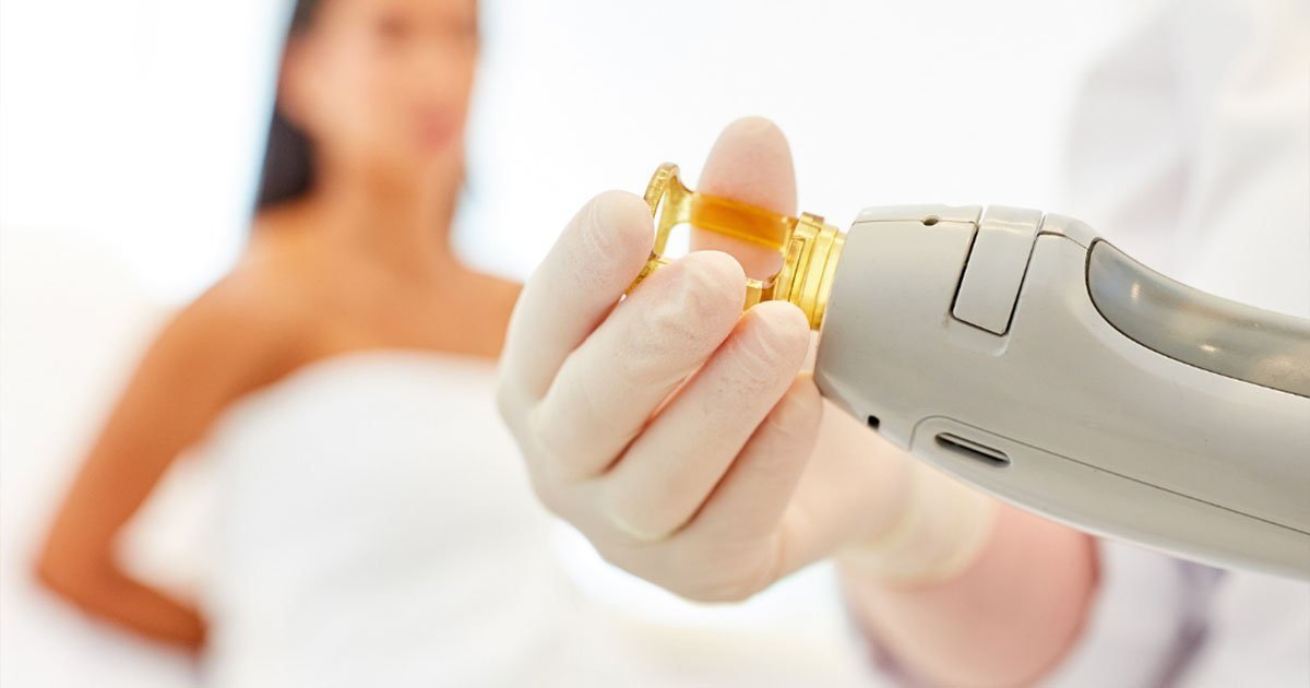 Gloved laser specialist holding a laser hair removal handpiece